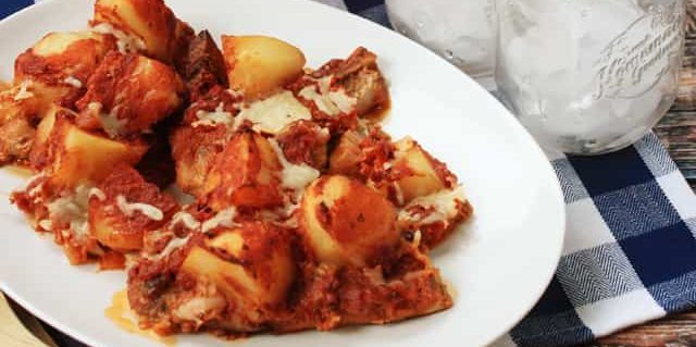 Babi dengan kentang, jamur dan saus tomat dalam oven