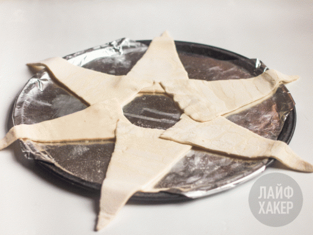 cincin ham dan keju puff: lipat adonan segitiga menjadi cincin yang tumpang tindih di atas loyang berlapis perkamen
