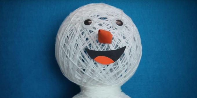 Snowman dengan tangannya sendiri: menambahkan mata, hidung dan mulut
