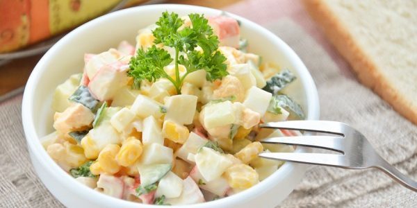 Salad dengan kepiting tongkat, jagung dan telur