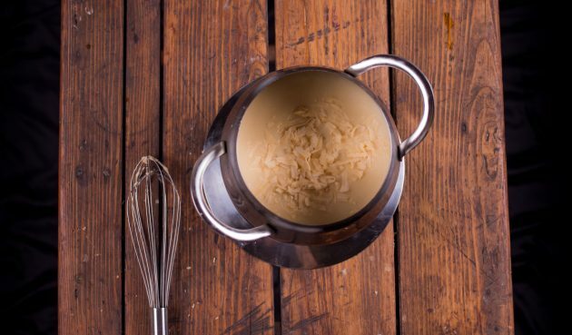 Cara membuat fondue keju: tambahkan keju ke alkohol dan aduk