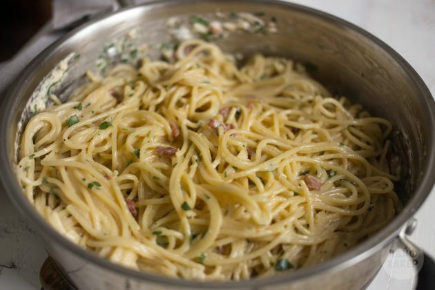 Cara membuat pasta carbonara: tambahkan saus, bacon, dan bumbu ke spageti